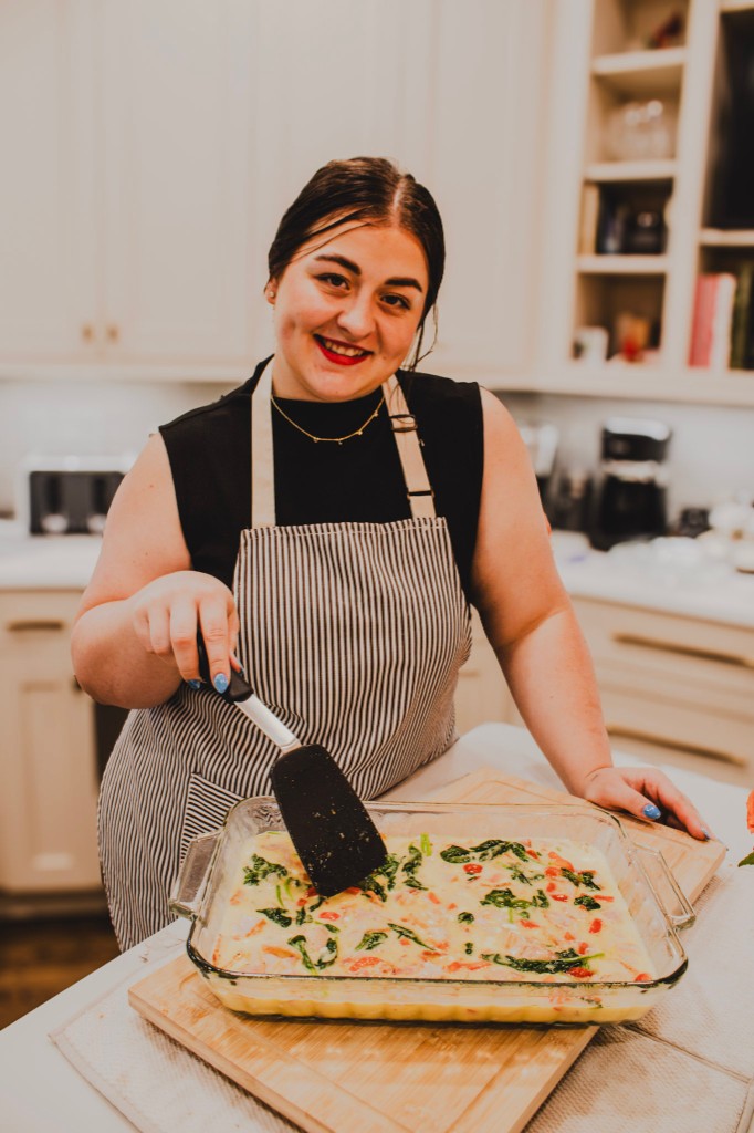 Kyla preparing a baked dish at the kitchen counter