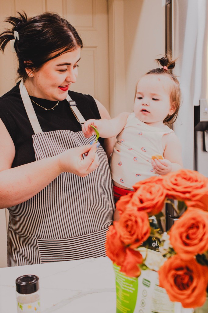 Kyla in the kitchen with her child, sharing a moment over fresh herbs